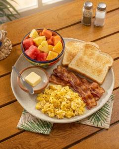 a plate of breakfast food with eggs bacon and toast at Casa Barú in Barú +38 photos