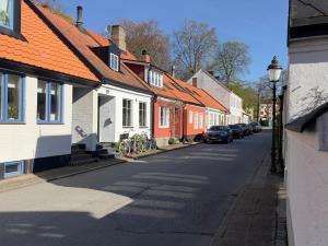 a street with a row of houses with cars parked at Tiny flat - in medieval Ystad in Ystad