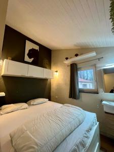 a bedroom with a bed and a window at Chalet de la fée Marion et Alice in Virton