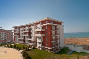 an apartment building with the ocean in the background at Marina and Panorama Apartments in Sveti Vlas