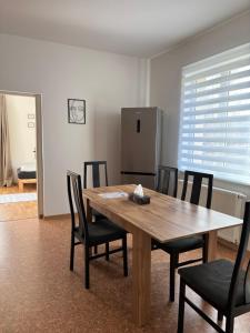 a dining room table with chairs and a refrigerator at Apartment 3 Stavební in Cheb