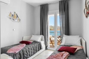 a bedroom with two beds and a view of the ocean at Haraki Aqua Marine in Haraki