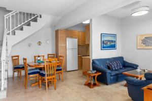 a living room with a blue couch and a table at Haraki Aqua Marine in Haraki