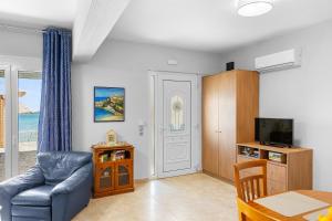a living room with a blue couch and a table at Haraki Aqua Marine in Haraki