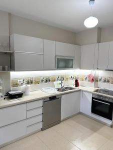 a kitchen with white cabinets and a sink at Velipoja Apartment in Velipojë