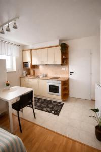 a kitchen with a white table and a kitchen with a stove at Apartmán U Onky in Luhačovice