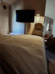 a hotel room with a bed and a flat screen tv at BelleLiv in Nijlen
