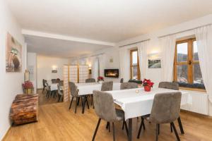 a dining room with white tables and chairs and windows at Penzion Quest in Loket