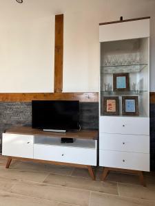 a white entertainment center with a flat screen tv at Studio Lec in Giżycko