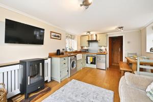 a kitchen with a living room with a fireplace at Plum Pudding Stables by Bloom Stays in Faversham +16 photos