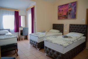 a room with two beds and a painting on the wall at Hotel Holy Miracle in Međugorje