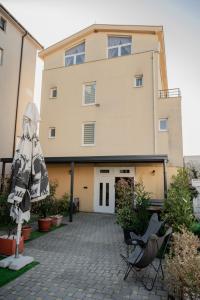 a building with chairs and an umbrella in front of it at Hotel Holy Miracle in Međugorje