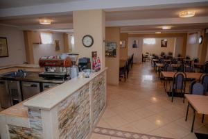 a restaurant with tables and chairs and a clock on the wall at Hotel Holy Miracle in Međugorje
