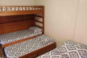 two bunk beds in a small room at Apto novo com ampla sacada e piscinas in Guarujá +20 photos