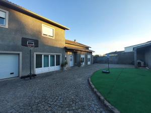 a house with a basketball hoop in a yard at Casa Flamingo in Viseu