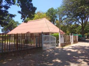 a fence with a gate in front of a building at Bed & Breakfast T.T in Río Hato