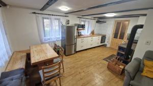 a kitchen with a table and a kitchen with a refrigerator at Chalupa Kruh in Doksy