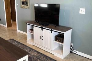 a entertainment center with a flat screen tv on top at Salty Paws II in Kill Devil Hills