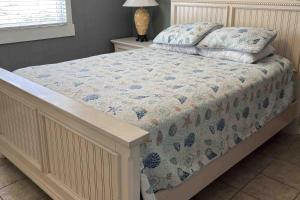 a bed with a quilt on it in a bedroom at Salty Paws II in Kill Devil Hills