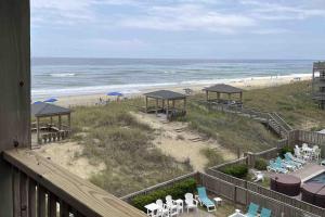 a view of a beach with chairs and umbrellas at Salty Paws II in Kill Devil Hills