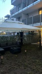 a couch under a large white umbrella in front of a building at Aurora Apartment in Vienna