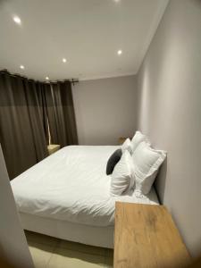 a bedroom with a bed with white sheets and pillows at Ocean Haven in Walvis Bay