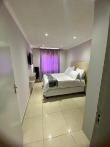 a bedroom with a bed and a purple window at Ocean Haven in Walvis Bay