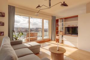 a living room with a couch and a large window at ZEN Rezidential Apartments in Cluj-Napoca