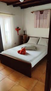 a bed with a red stuffed animal on it at Bed & Breakfast T.T in Río Hato