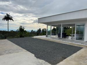 a house with a gravel driveway and a palm tree at casa campestre la daniela in Filandia