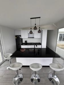 a kitchen with a black counter and two stools at casa campestre la daniela in Filandia