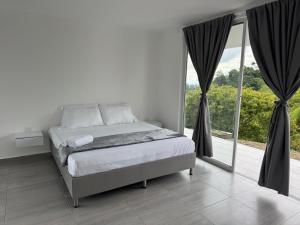 a bedroom with a bed and a large window at casa campestre la daniela in Filandia