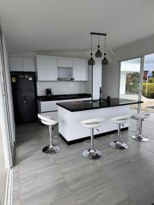a kitchen with a counter and four bar stools at casa campestre la daniela in Filandia +40 photos