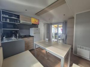 a small kitchen with a table and a counter top at Mobil Home 3Ch Confort- 6Pers 15min Europa PARK in Boofzheim
