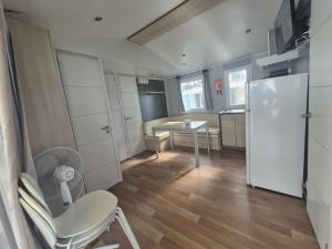 a kitchen with a white refrigerator and a table at Mobil Home 3Ch Confort- 6Pers 15min Europa PARK in Boofzheim