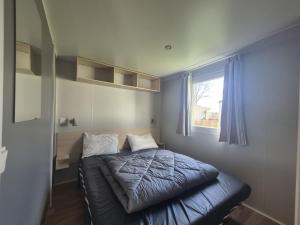a small bed in a room with a window at Mobil Home 3Ch Confort- 6Pers 15min Europa PARK in Boofzheim +16 photos