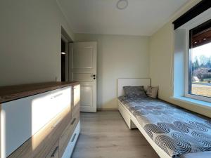 a bedroom with a bed and a window at Vahtralehe majutus in Tartu +9 photos