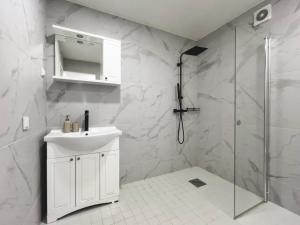 a white bathroom with a sink and a shower at Vahtralehe majutus in Tartu