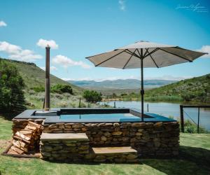 an umbrella sitting on top of a stone pool at Uitkyk Kliphuisie in Uniondale