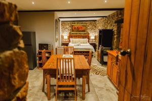 a bedroom with a bed and a table and chairs at Uitkyk Kliphuisie in Uniondale