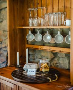 a table with cups and mugs on a shelf at Uitkyk Kliphuisie in Uniondale