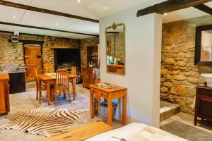 a living room with a table and a stone wall at Uitkyk Kliphuisie in Uniondale