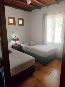 a bedroom with two beds and a lamp on a table at Bed & Breakfast T.T in Río Hato +19 photos