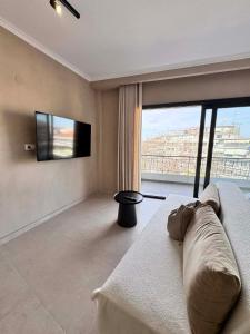 a living room with a couch and a flat screen tv at Nest Studio in Katerini