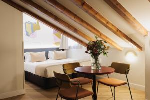 a bedroom with a bed and a table with chairs at Blume Cruz Suites in Madrid