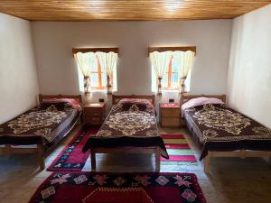 a room with two beds and two windows at Guest House Prebibaj in Curraj i Epërm +7 photos