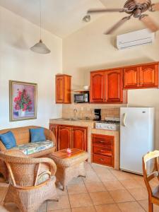 a kitchen with a couch and a refrigerator at Seville Suite in San Juan del Sur