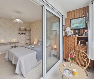 a bedroom with a bed and a sliding glass door at Sérénité vue mer in Courseulles-sur-Mer +19 photos