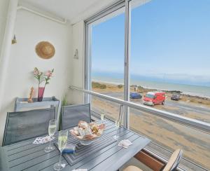 a dining room with a table and a view of the beach at Sérénité vue mer in Courseulles-sur-Mer