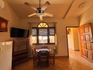 a dining room with a table and a ceiling fan at Seville Suite in San Juan del Sur